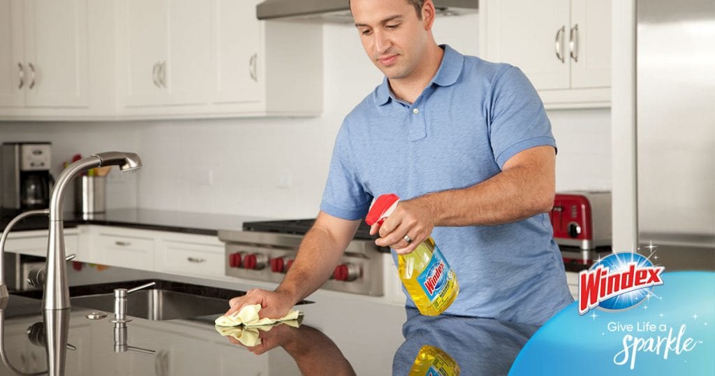 Using Windex to clean countertops in the kitchen