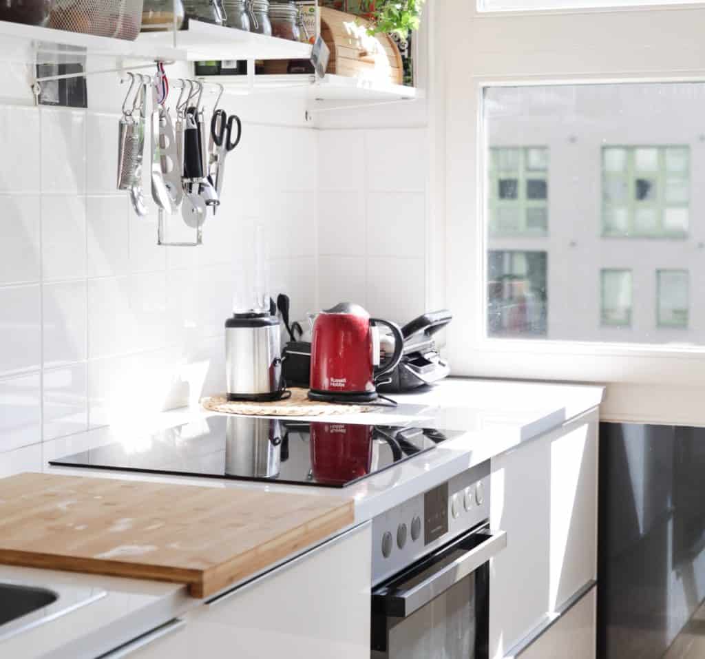 kitchen counter with stove and red kettle